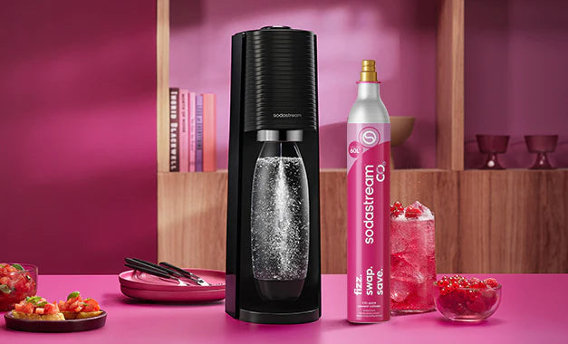 Black Sodastream sparkling water maker with a pink CO2 cylinder and pink sparkling drinks
