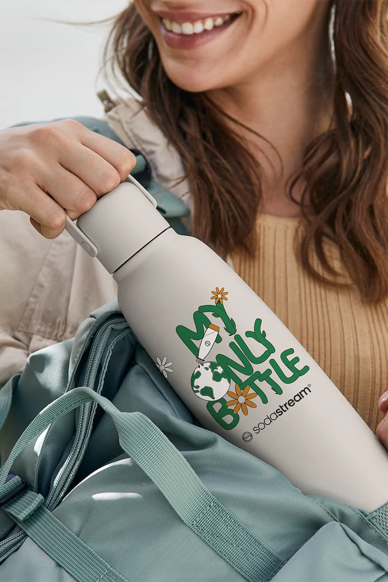 Person packing the Sodastream Fizz & Go Earth Day bottle into a backpack