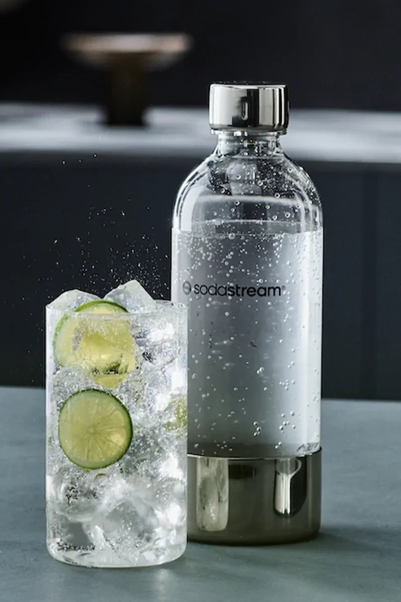 Sodastream ENSO 1 litre bottle of sparkling water next to a glass with ice and lime slices